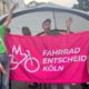 Drei Leute vom Fahrrad-Entscheid halten beim Bonner Straßenfest ein Banner mit unserem Logo hoch.